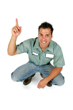 An adult male serviceman employee worker with blank name tag on shirt is pointing up.
