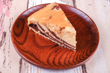 Slice of homemade marble cake on a wooden plate with vintage wooden table background