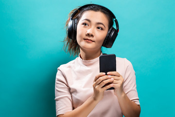 Fototapeta premium Happy woman dancing and listening to the music from smartphone