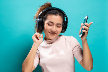 Happy woman dancing and listening to the music from smartphone