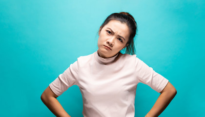 Portrait of angry woman standing on blue background