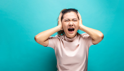 Portrait of angry woman standing on blue background