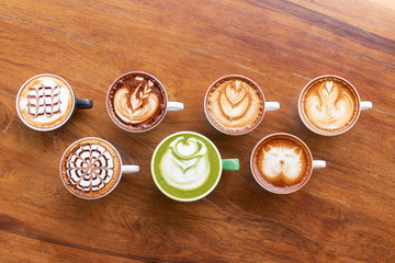 Coffee cup with Green Matcha latte art foam on wood table in coffee shop with copy space.Coffee is one of the most popular beverages.Improve Energy Levels and Burn Fat