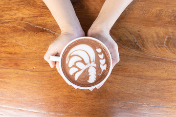 Coffee cup with latte art foam on wood table in coffee shop with copy space.Coffee is one of the most popular beverages.Improve Energy Levels and Burn Fat