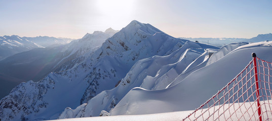 Panorama of the Caucasus Mountains in the ski resort, protective red grid trails