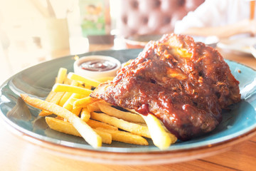 Pork steak and french fries on plate in restaurant .