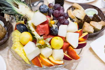 plate with fresh mixed fruits on table in cafe