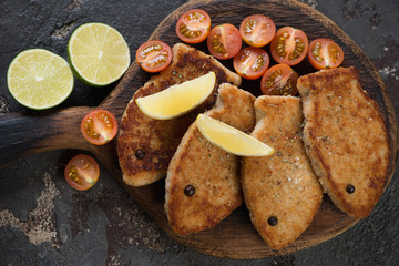 Top view of roasted fish cutlets made of pike fillet on a rustic wooden serving board, studio shot