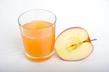 half apple with glass of naturally cloudy juice