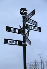 Old metal post with signs of cities