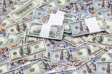 One hundred dollar bills on the table as background