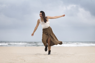 Obraz premium Lifestyle portrait of happy carefree woman walking on the beach
