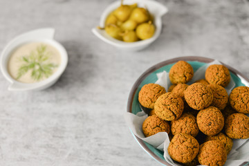 Baked chickpea falafel balls on blue plate on grey background , healthy and vegan food with tahini deep and hot pepper , traditional Mediterranean , top view , flat lay with copy space  