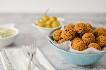 Baked chickpea falafel balls on blue plate on grey background , healthy and vegan food with tahini deep and hot pepper , traditional Mediterranean , top view , flat lay with copy space  