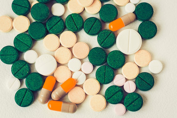 Medicine green, pink and yellow pills or capsules on white background with copy space. Drug prescription for treatment medication. Blister pack.