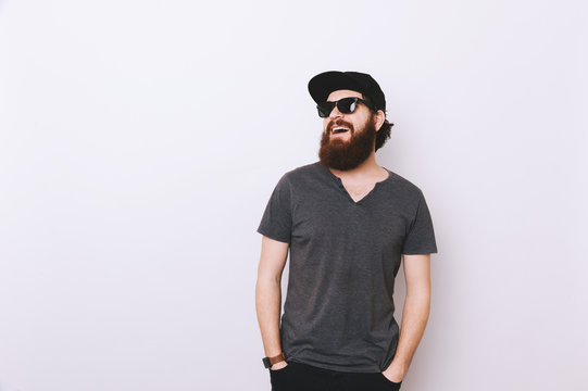 Portrait of happy bearded man in hat and sunglasses looking away