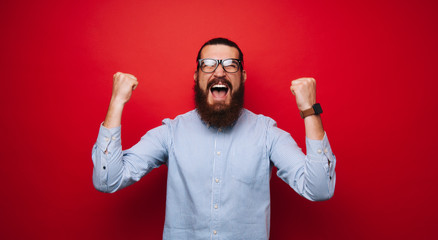 Portrait of screaming man, celebrating his victory and gesturing with fists up