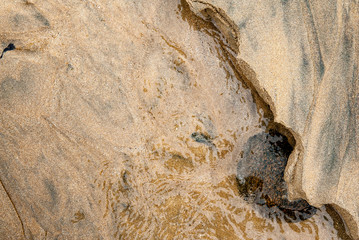 Game of material and reflections created by the sand and water of a beach in northern Brittany