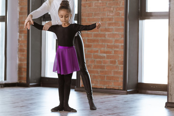 The choreographer teaches children to dance. Kids dance class in loft studio with windows and...