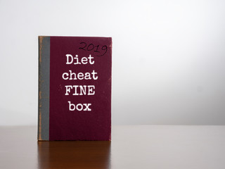 Diet cheat fine box, 2019. On desk. Resolution to lose weight