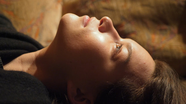 Close Up Profile Shoot Of A Young Woman Staring At Ceiling And Dreaming 