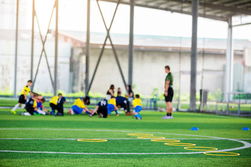 equipment on green artificial turf with blurry kid players training background