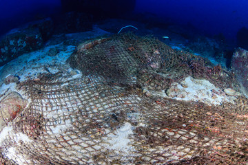 An abandoned Ghost fishing net entangled on corals on a tropical reef