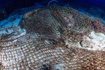 An abandoned Ghost fishing net entangled on corals on a tropical reef