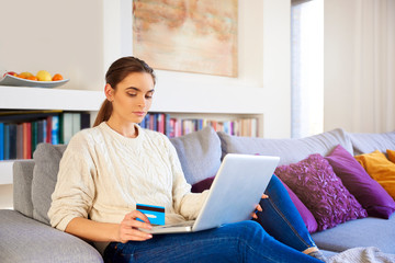 Woman and shopping online with her credit card on laptop