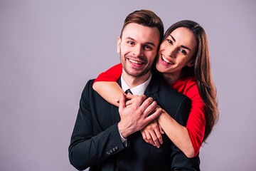 Love you so much! Beautiful stylish and elegant couple in suit and dress are hugging, have a fun and posing isolated in studio. Holidays and events. St Valentine's day. Day of lovers