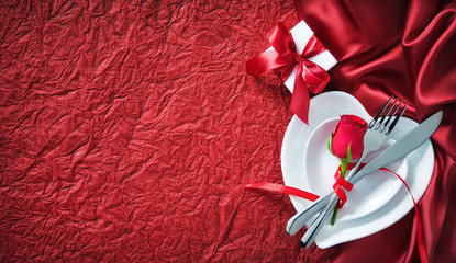 holidays table setting with a gift box on red background