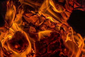 Campfire bright heat flame background. Bonfire bright yellow orange flame. Strong fire close up. Holiday cosy chimney fireplace.