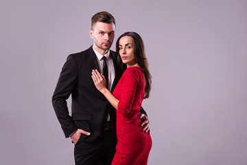 Love you so much! Beautiful stylish and elegant couple in suit and dress are hugging, have a fun and posing isolated in studio. Holidays and events. St Valentine's day. Day of lovers
