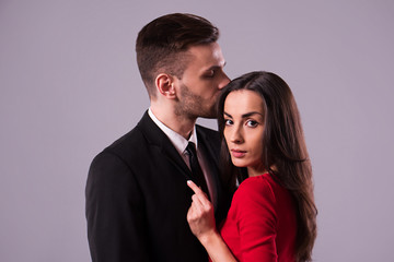 Love you so much! Beautiful stylish and elegant couple in suit and dress are hugging, have a fun and posing isolated in studio. Holidays and events. St Valentine's day. Day of lovers
