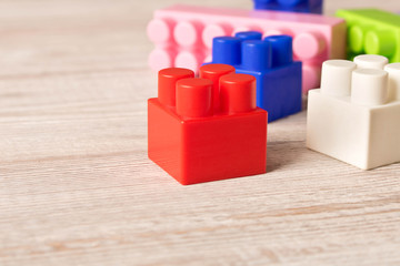 Multi-colored plastic construction set on the wooden table . Children's educational games. Close up