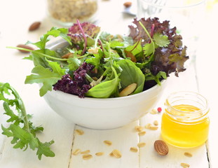 Mix leaves of organic green salad with nuts, oat flakes and seeds