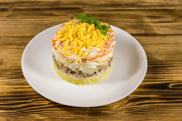 Traditional russian salad Mimosa on wooden table