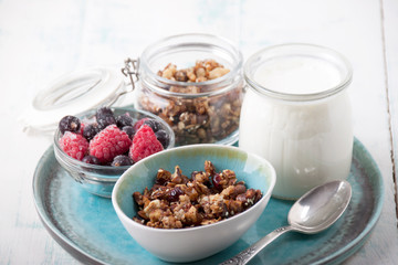 Homemade granola in glass jar   and yogurt in glass  for breakfast