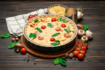 Traditional quiche tart in baking form with filling