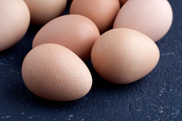 Eggs of guinea fowl on blue background closeup