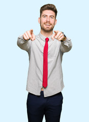 Young handsome business man Pointing to you and the camera with fingers, smiling positive and cheerful