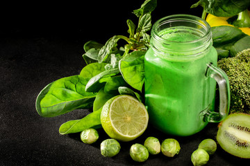 Healthy green vegetables smoothie in the jar on rustic wooden background