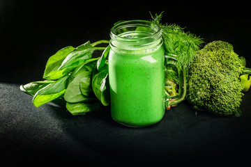 Healthy green vegetables smoothie in the jar on rustic wooden background