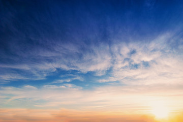 Sky blue and orange light of the sun through the clouds in the sky