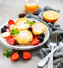 Delicious pancakes with berries on a concrete backrgound