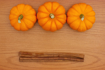 Pumpkin Spice background with a pumpkins and cinnamon sticks on wood