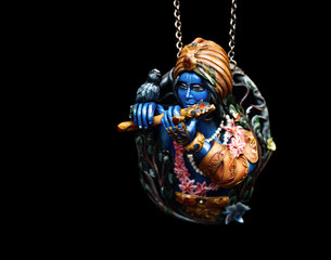 Krishna handmade pendant isolated on black.