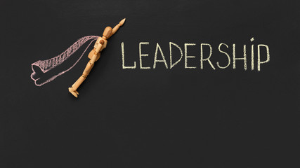 Wooden dummy puppet as superhero on black