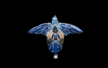 Handmade polymer clay pendant with bluebird of happiness holding in hands symbol of luck in art nouveau style with filigree and enamel on black background