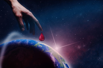 Human hand blood drop. Nebula dust in infinite space. World Blood Donor Day. Mixed media.